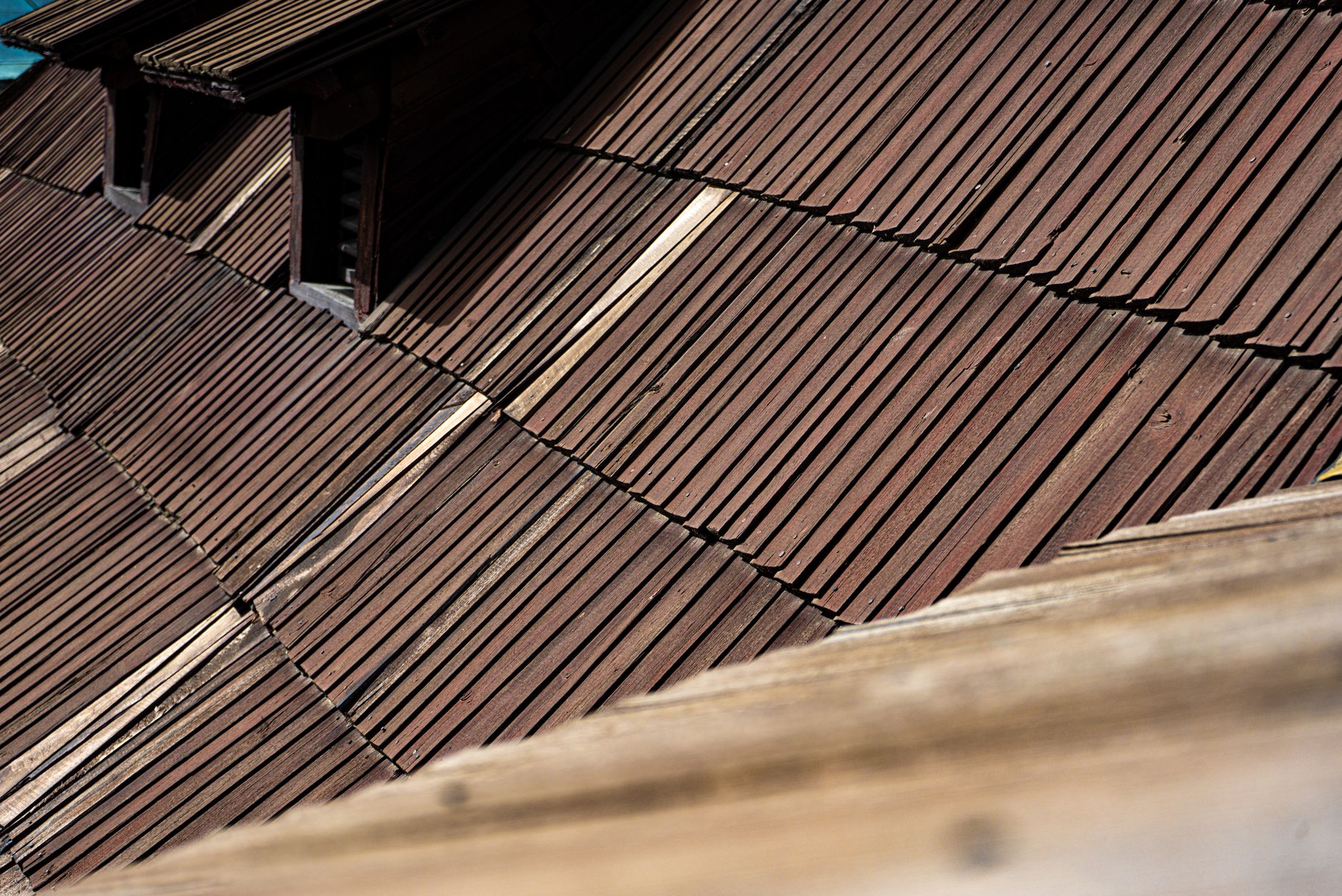 Detailed view of aged wooden roof shingles showcasing texture and architectural style.