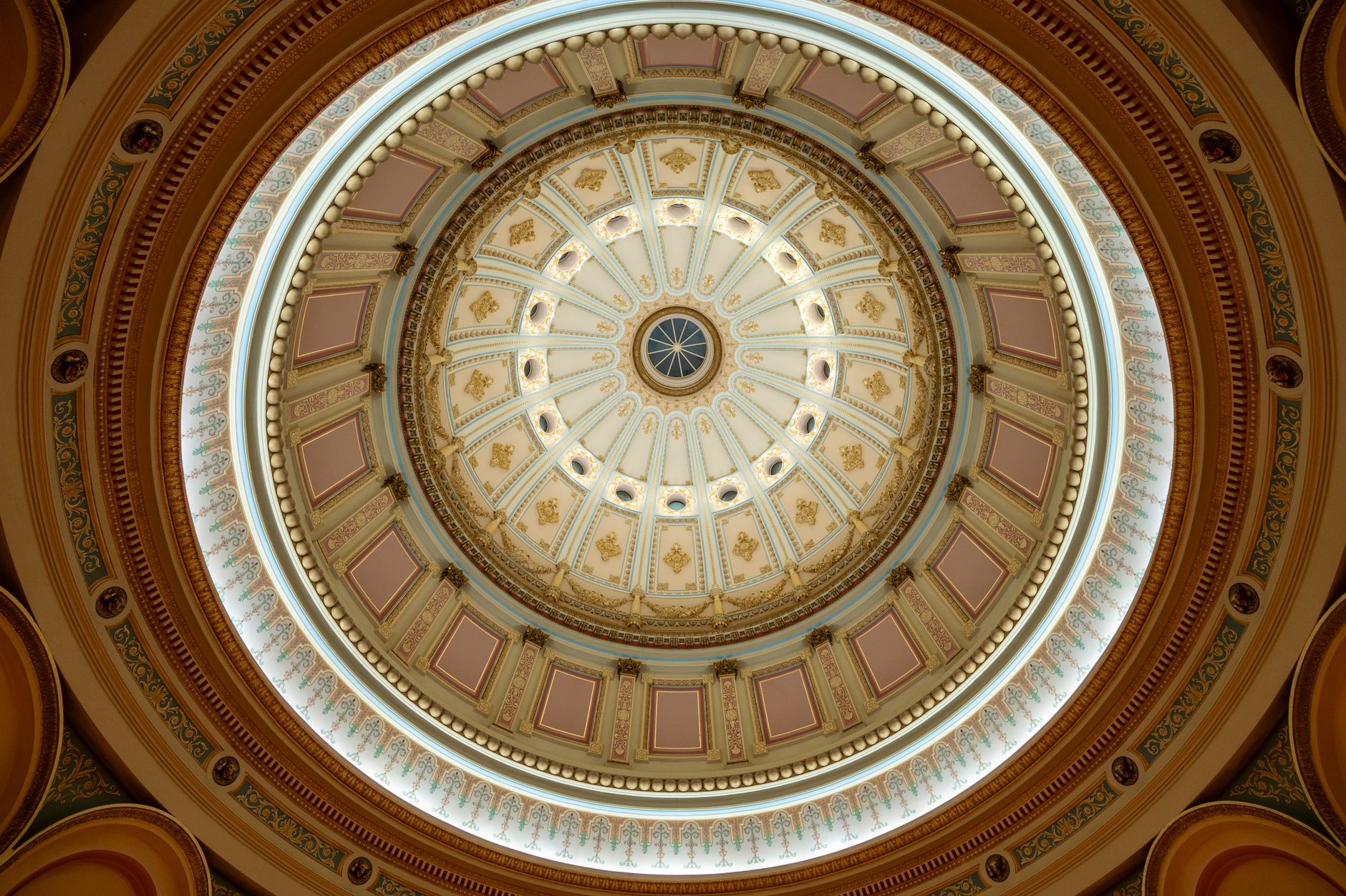 Intricate dome ceiling with ornate architectural details and lighting, viewed from below.