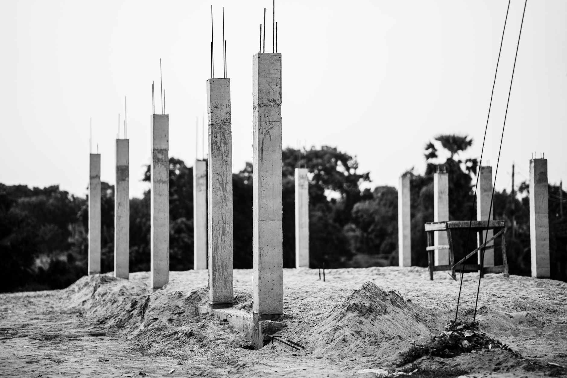 Black and white image of concrete pillars at an unfinished construction site in Faridpur, Bangladesh.