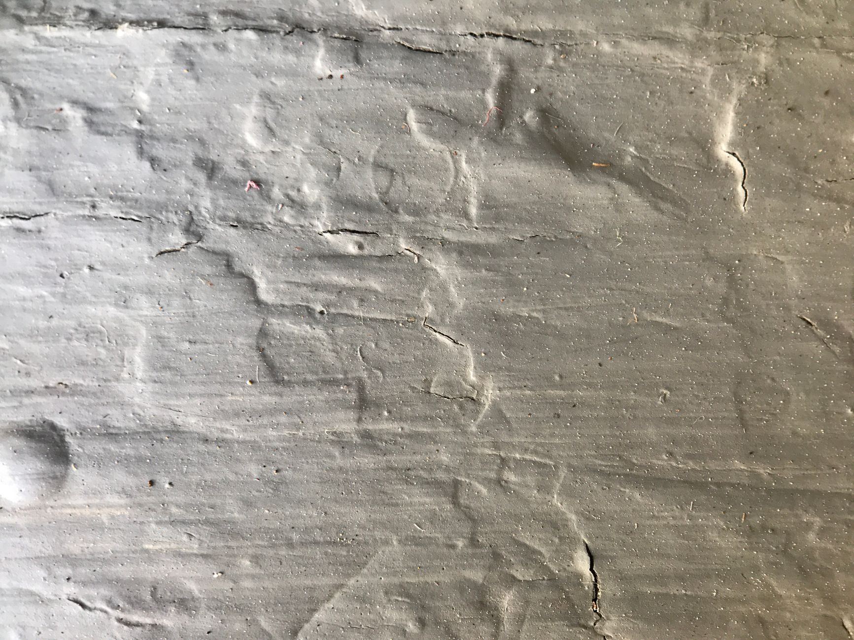 Detailed close-up of a rough textured concrete wall surface, perfect for backgrounds.