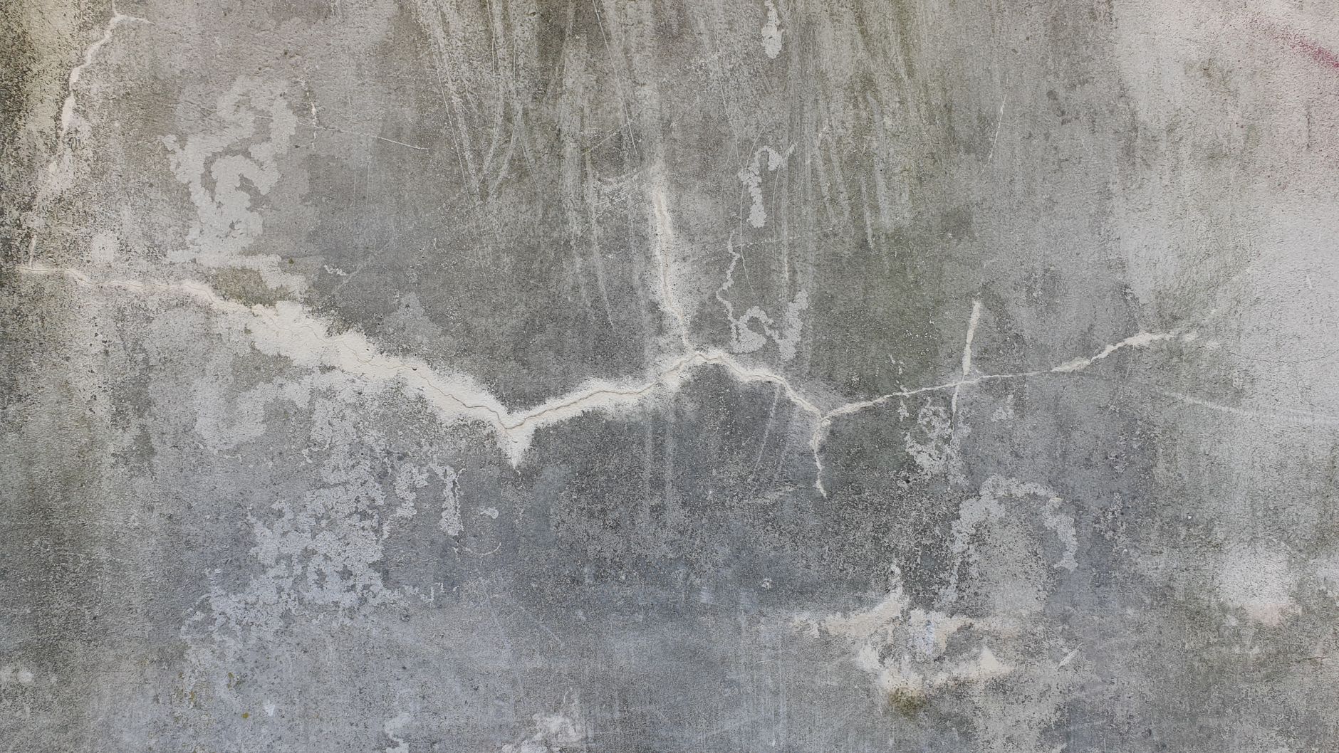 High-resolution image of a weathered and cracked concrete wall, perfect for texture background uses.