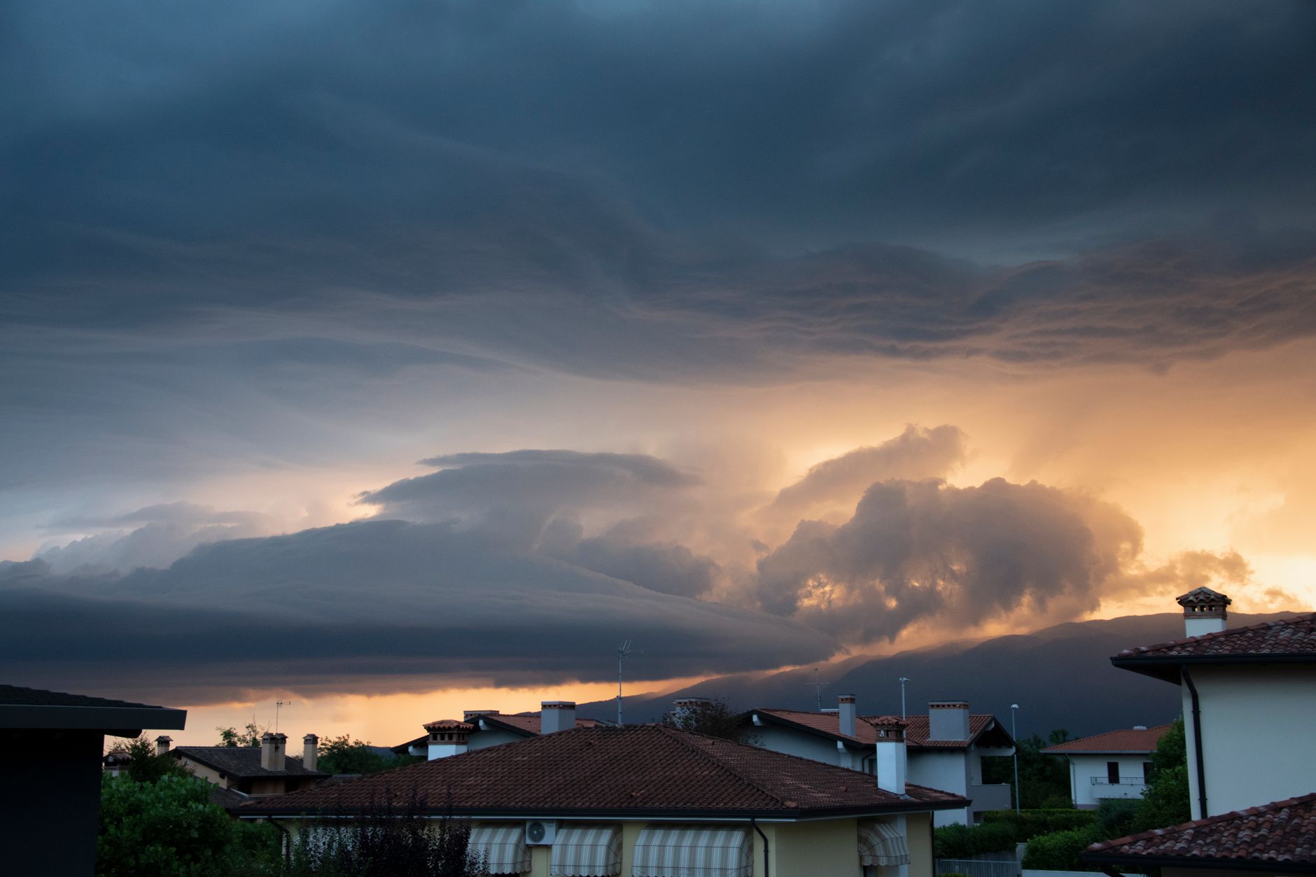 A breathtaking sunset over Roveredo in Piano, Italy with dramatic and overcast clouds.