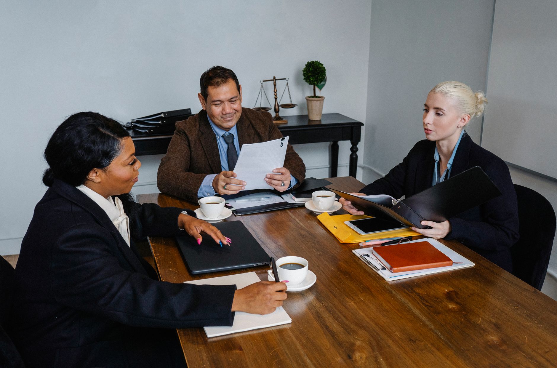 Group of diverse coworkers in formal suits discussing business issues during meeting in office