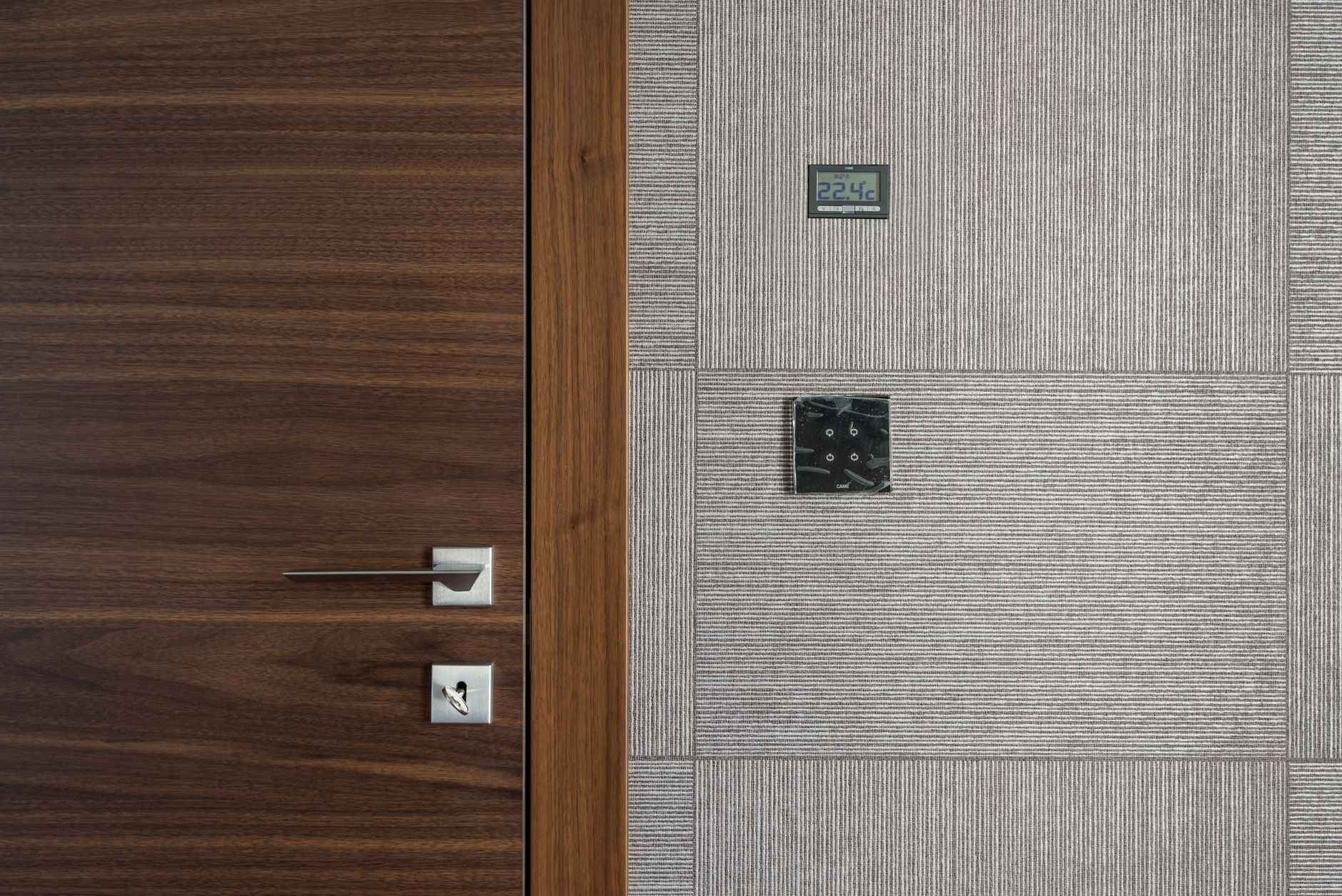 Sleek modern wooden door with stainless steel handle and 22.4°C display.